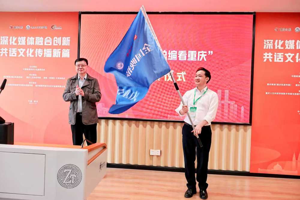 中国晚协执行会长、原新华报业集团党委委员、扬子晚报总编辑王文坚向重庆晚报总编辑杨飞授旗